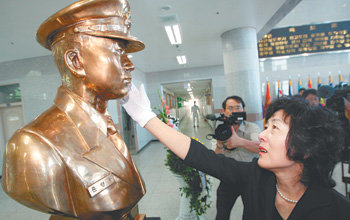 “내 아들 영하야.” 13일 경남 진해시 해군사관학교에서 열린 제2연평해전 전사자 윤영하 소령 흉상 제막식에서 어머니 황덕희 씨가 아들의 흉상을 어루만지며 눈물을 글썽이고 있다. 진해=연합뉴스