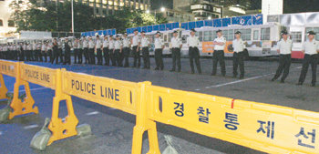 촛불문화제 참석자들이 15일 새벽 미국산 쇠고기 수입과 관련한 재협상을 촉구하며 거리 행진에 나서자 경찰이 서울 종로구 세종로 사거리 일대에 통제선을 설치하고 청와대로 가지 못하도록 막았다. 김재명 기자