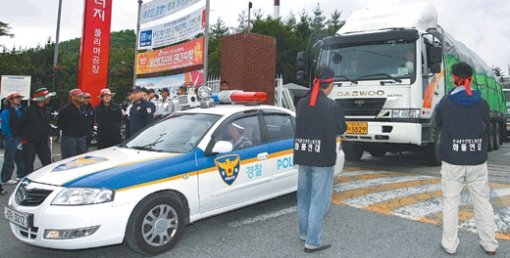 물류수송 군사작전 방불수출 화물을 실은 차량들이 17일 울산 남구 SK에너지 폴리머 공장을 나서고 있다. 화물연대 조합원들이 막으려고 했으나 경찰이 호위해 울산화주물류협의회 소속 23개 운송업체가 일제히 제품을 실어 날랐다. 울산=연합뉴스