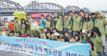 청소년탐방단이 15일 중국 랴오닝 성 단둥 시에서 북한으로 들어가는 단둥철교를 배경으로 기념촬영을 하고 있다. 단둥=홍진환 기자