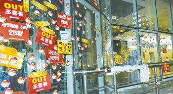 16일 촛불집회에 참가한 일부 시위대가 서울 종로구 세종로 동아일보 사옥으로 몰려와 외벽과 유리문에 ‘OUT 조중동’ 등이 적힌 스티커를 무더기로 붙였다. 이들은 촛불을 흔들면서 “동아일보 폐간하라”고 주장하기도 했다. 박영대  기자