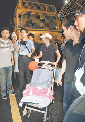 “위험하다” 경찰 설득도 안 통해아기를 유모차에 태우고 26일 서울 종로구 세종로 사거리의 촛불집회에 참석했던 주부. 그는 경찰이 물대포를 사용하려고 하자 살수차 앞을 가로막았다. 김재명 기자