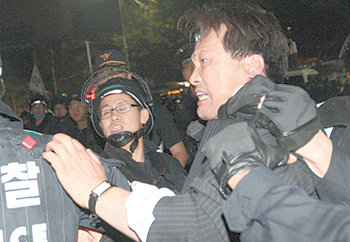 통합민주당 안민석 의원이 27일 서울 종로구 세종로 사거리에서 경찰에 끌려나오고 있다. 경찰과 시위대의 물리적 충돌을 막겠다고 인간 띠를 만들다가 경찰과 마찰을 빚은 뒤였다. 연합뉴스