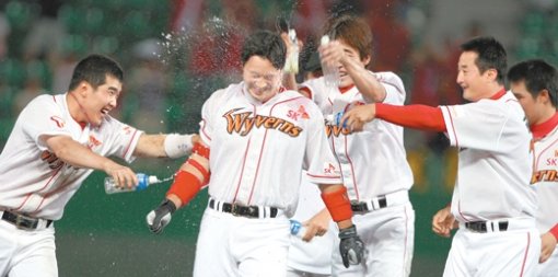 “아무리 뿌려도 좋아”SK 김재현(가운데)이 한화와 1-1로 맞선 연장 15회말 2사 만루에서 끝내기 안타를 친 뒤 동료들로부터 축하를 받고 있다. 인천=연합뉴스