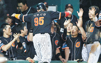 가르시아 ‘덩실 덩실’롯데 카림 가르시아(가운데)가 5-3으로 앞선 5회 3루에 있다가 정보명의 안타 때 홈을 밟은 뒤 동료들의 환호에 두 팔을 활짝 뻗고 있다. 연합뉴스