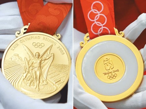 베일 벗은 금메달베이징 올림픽 조직위원회가 1일 공개한 대회 금메달. 앞면(왼쪽)에는 그리스 신화에 나오는 승리의 여신 니케를, 뒷면에는 이번 대회 엠블럼인 ‘춤추는 베이징’을 넣고 그 둘레를 옥으로 치장했다. 베이징=로이터 연합뉴스