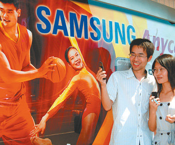 올림픽을 앞두고 중국 베이징 시내 곳곳에 설치된 삼성 휴대전화 광고판 앞에서 중국 젊은이들이 통화를 하고 있다. 사진 제공 삼성전자