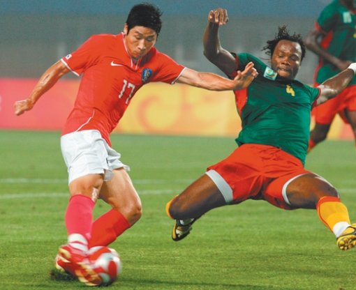 치열한 공방전한국의 공격수 이근호(왼쪽)가 카메룬 수비수 비케이의 몸을 날리는 태클에 앞서 슛을 날리고 있다. 친황다오=올림픽사진공동취재단