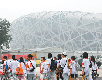 베이징 올림픽 개회일인 8일 오전 개회식이 열리는 주경기장 ‘냐오차오’ 주변에서 시민들이 구경을 하고 있다. 이날 안개와 스모그로 주경기장 모습이 흐릿하게 보인다. 베이징=원대연 기자
