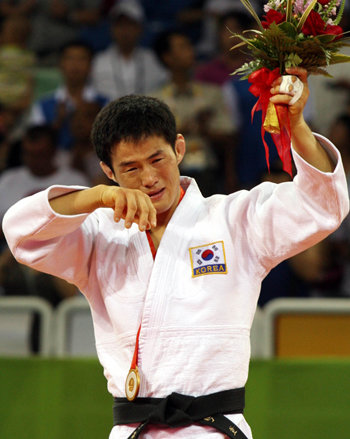 한국 선수단에 첫 금메달을 안긴 유도 남자 60kg급 최민호가 시상대에서 꽃다발을 든 채 기쁨의 눈물을 흘리고 있다. 베이징=올림픽사진공동취재단