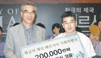20만 번째 관람객인 최익준 씨(오른쪽)가 최광식 국립중앙박물관장으로부터 선물을 받았다. 김재명 기자