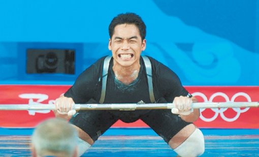 이배영이 역도 남자 69kg급 용상 184kg 3차 시기에서 실패한 뒤 무릎을 꿇은 채 바를 놓지 못하고 안타까워하고 있다. 베이징=올림픽 사진공동취재단