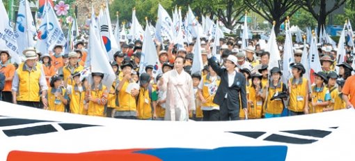 “희망찬 대한민국으로” 한복 차림의 이명박 대통령(앞줄 가운데)이 15일 건국 60년 및 광복 63주년 기념식이 끝난 뒤 ‘국토대장정 미래대행진’에 참가해 김형오 국회의장(앞줄 오른쪽), 학생 등과 함께 태극기를 흔들며 서울 종로구 세종로 광화문 앞에서 서울시청 앞 서울광장까지 걸어가고 있다. 이종승 기자