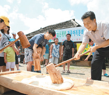 이성우 삼진제약 사장(오른쪽)이 이달 초 강원 양양군의 한 산골마을에서 여름휴가를 보내고 있는 직원들과 함께 떡메를 치고 있다. 사진 제공 삼진제약