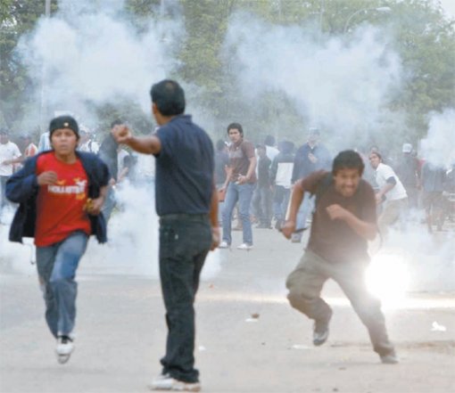 19일 볼리비아 동부 산타크루스에서 시위대가 최루가스를 쏘는 경찰에 맞서 돌을 던지며 저항하고 있다. 산타크루스 주민들은 중앙정부의 권한 확대 등 에보 모랄레스 대통령의 정책에 반발해 총파업에 들어갔다. 산타크루스=AFP 연합뉴스