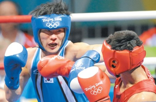한국의 김정주(왼쪽)가 22일 베이징 노동자체육관에서 열린 복싱 웰터급(69kg) 준결승전에서 카자흐스탄의 바히트 사르세크바예프를 상대로 코피를 흘리면서도 경기에 임하고 있다. 베이징=올림픽사진공동취재단