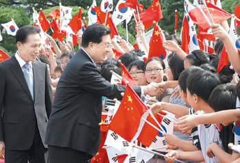 25일 방한한 후진타오 중국 국가주석(앞)이 청와대에서 이명박 대통령의 안내를 받으며 환영 나온 학생들의 손을 잡고 있다. 이종승 기자