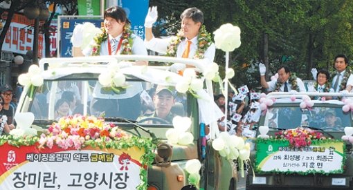 28일 경기 고양시에서 고양시청 소속의 장미란 선수 환영 행사가 열렸다. 카퍼레이드에서 장미란(왼쪽 차량 왼쪽)이 강현석 고양시장과 함께 오픈카를 타고 환영 나온 시민들에게 손을 흔들고 있다. 고양=연합뉴스