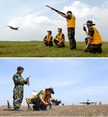 공군 제20전투비행단 소속 조류퇴치팀(BAT) 대원들이 28일 낮 KF-16 전투기가 이륙하는 동안 활주로 인근에서 기지 상공으로 야생 조류들이 접근할 것에 대비해 감시활동을 하고 있다. 조류퇴치팀은 엽총 외에 휴대용 발사통으로 폭음탄을 쏘아올려 활주로 상공으로 근접하는 새 떼를 쫓아낸다(아래 사진). 사진 제공 공군