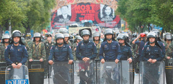 태국 수도 방콕에 비상사태가 선포된 가운데 2일 친정부 시위대가 점거하고 있는 정부청사 바깥에 긴급 배치된 경찰과 군인들이 경계 태세를 취하고 있다. 이날 새벽 정부청사에는 친정부 시위대가 몰려들어 유혈사태가 발생했다. 방콕=EPA 연합뉴스