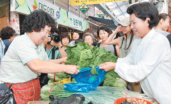 재래시장 찾은 金여사이명박 대통령 부인 김윤옥 여사(오른쪽)가 추석 연휴 시작 전날인 12일 서울 강북구 수유동 수유재래시장을 방문했다. 김 여사가 상인들과 추석 물가 등에 대해 얘기를 나눈 뒤 배추를 구입하고 있다. 연합뉴스