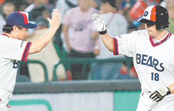 두산 김동주(오른쪽)가 5-5이던 연장 10회 초 롯데의 마무리 투수 최향남을 상대로 결승 솔로홈런을 터뜨린 뒤 3루를 돌며 김광수 코치와 하이파이브 하고 있다. 부산=연합뉴스