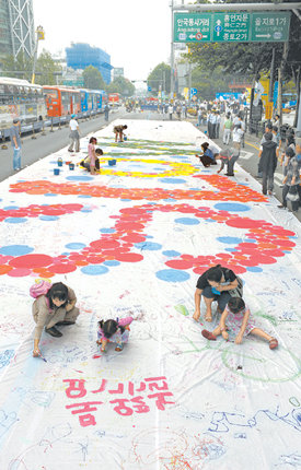 도화지가 된 도로‘차 없는 날’인 22일 서울 종로구 종로1가 차도 위에서 어린이들이 흰 천에 그림을 그리고 있다. ‘매연 없는 거리’라고 쓰인 문구가 눈에 띈다. 박영대 기자