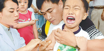 처음으로 독감 예방접종을 받는 만 8세 이하 어린이는 한 달 간격으로 두 번 맞아야 한다. 한 어린이가 독감 예방주사를 맞으며 아픈 표정을 짓고 있다. 동아일보 자료 사진