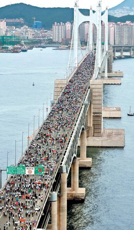 광안대교 걷기대회 성황28일 부산 광안대교에서 2008 부산세계사회체육대회 특별 이벤트로 열린 걷기대회에 참가한 2만여 명의 시민들이 6.5km 코스를 걸으며 장관을 이루고 있다. 대회조직위원회는 1인당 5000원의 참가비 가운데 1달러씩을 모아 유엔아동기금(UNICEF·유니세프)에 세계 기아아동돕기 성금으로 전달하기로 했다. 부산=최재호  기자