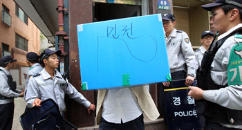 경찰이 27일 오전 서울 성북구 삼선동 남북공동선언실천연대 사무실을 압수수색해 사무실에서 확보한 자료를 상자에 담아 옮기고 있다. 연합뉴스