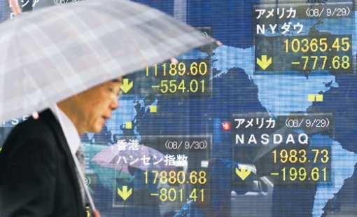 日 떨어진 화살표30일 일본 도쿄에서 우산을 쓴 한 남성이 전 세계의 주가 하락을 알리는 증권회사 전광판 앞을 지나고 있다. 미국 하원에서 구제금융법안이 부결된 뒤 이날 일본 닛케이평균주가는 전날 종가에 비해 4.12% 떨어진 11,229.86엔으로 장을 마쳤다. 도쿄=AFP 연합뉴스