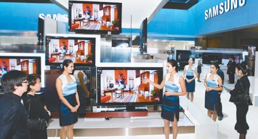 삼성전자 홍보도우미들이 14일 경기 고양시 킨텍스 한국전자산업대전 전시장에서 LED 백라이트를 채용해 친환경적 요소를 강조한 LCD TV를 소개하고 있다. 사진 제공 삼성전자