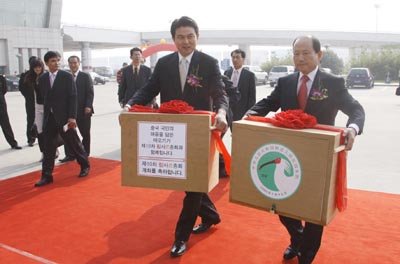 따오기 수송작전-중국 산시성 서안공항에서 개최된 따오기 기증식을 마치고 김태호 도지사와 김충식 창녕군수가 특수 상장에 담긴 따오기를 조심스럽게 옮기고 있다. [동아일보]