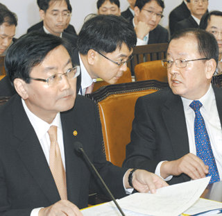 姜재정, 부하직원과 답변 상의27일 국회 기획재정위원회 전체회의에서 강만수 기획재정부 장관(앞줄 오른쪽)이 국회의원들의 질의를 받던 중 고개를 돌려 재정부 육동한 경제정책국장과 상의하고 있다. 이날 정부는 국내 은행의 외화차입 지급보증안 처리를 시도했지만 의원들이 “은행들의 자구책이 부실하다”고 강하게 지적해 회의가 지연되기도 했다. 전영한  기자