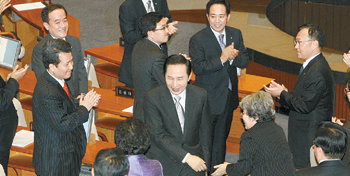 이명박 대통령이 27일 국회에서 작금의 금융위기를 극복할 수 있다며 희망을 갖자는 내용의 시정연설을 마친 뒤 본회의장을 나서면서 기립박수를 보내는 한나라당 의원들과 악수하고 있다. 전영한 기자