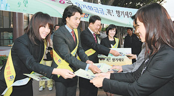 한상률 국세청장(왼쪽에서 세 번째)과 국세청 명예홍보위원인 탤런트 송일국 김선아 씨가 29일 서울 지하철 5호선 광화문역 입구에서 유가 환급금 홍보물을 시민들에게 나눠주고 있다. 연합뉴스