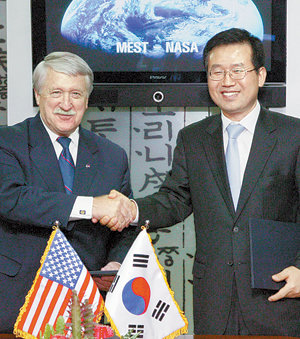 이문기 교육과학기술부 거대과학지원관(오른쪽)과 마이클 오브라이언 미국항공우주국 대외협력국장이 30일 서울 종로구 세종로 정부중앙청사에서 양국 간 우주항공 공동 협력의향서에 서명한 뒤 악수하고 있다.