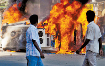 30일 인도 동북부 아삼 주의 주도 가우하티 중심지 가네시구리에서 폭발로 불타고 있는 자동차를 시민들이 지켜보고 있다. 이날 아삼 주 일대에서는 테러로 추정되는 연쇄 폭발 사고가 일어나 많은 시민이 숨졌다. 가우하티=EPA 연합뉴스