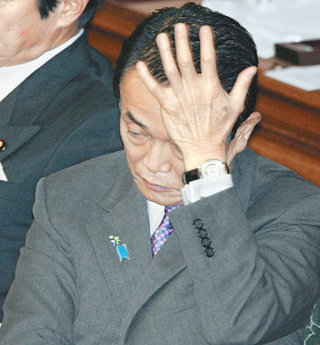 안팎의 공격에 시달리고 있는 아소 다로 일본 총리가 18일 중의원 본회의 도중 피곤한 듯 한 손으로 머리를 감싸고 있다. 도쿄=로이터 연합뉴스