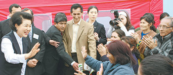 김윤옥여사 빈민촌 방문 이명박 대통령과 함께 페루를 방문 중인 김윤옥 여사(왼쪽)가 21일(현지 시간) 페루의 대표적 빈민가인 파차쿠텍 모자보건소를 방문한 자리에서 환영 나온 주민들에게 손을 흔들고 있다. 이 모자보건소는 우리나라가 92만여 달러(약 13억8400만 원)를 무상 지원해 지난해 10월 개원했다. 리마=이종승 기자