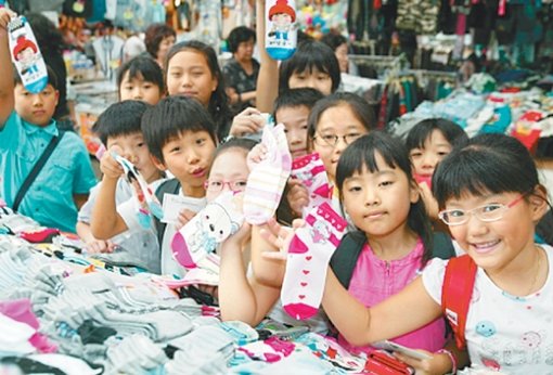 “재래시장에서 양말 샀어요” 30일 ‘재래시장 배우기’에 나선 대구지역 초등학생들이 시장 좌판에서 양말을 들어 보이고 있다. 대구시는 내년 1월부터 시내 205개 초등학교 학생 3만2000여 명을 대상으로 장보기 체험 학습을 실시키로 했다. 정용균  기자