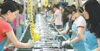 LG전자 경북 구미 TV공장에 지난해 6월 설치된 흐름라인은 생산성 향상에 크게 기여했다. 근로자들이 멈추지 않고 이동하는 100m 길이의 컨베이어벨트 조립 라인에서 맡은 작업을 하고 있다. 사진 제공 LG전자