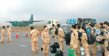 자이툰부대의 3차 철수 병력들이 11일 오후(현지 시간) 이라크의 아르빌 공항에 도착한 공군 다이만부대 소속 C-130 수송기를 바라보고 있다. 아르빌=윤상호  기자