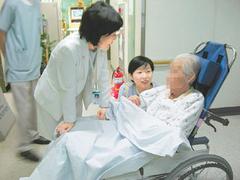 강남성모병원 호스피스센터 박명희 수간호사(왼쪽)가 임종을 앞둔 한 환자의 건강 상태를 물어보고 있다. 사진 제공 강남성모병원