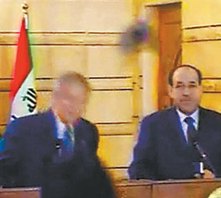 14일 이라크를 고별 방문한 조지 W 부시 미국 대통령(왼쪽)이 기자회견 도중 이라크 기자가 던진 신발을 피하고 있다. AFP 연합뉴스