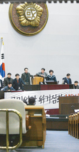 국회 폭풍전야 26일 한나라당의 법안 단독처리를 막는다는 명분으로 국회 본회의장을 기습 점거한 민주당 의원들이 국회의장석 주변에 ‘국민억압 위기심화 MB악법 날치기 결사반대’라고 쓰인 플래카드를 두른 채 농성을 벌이고 있다. 전영한 기자