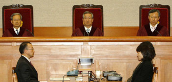 26일 서울 종로구 재동 헌법재판소에서 이강국 헌재 소장(가운데) 등 전원재판부가 미국산 쇠고기 수입위생조건 고시에 대한 헌법소원 사건 결정을 선고하고 있다. 헌재 재판부는 “이 고시가 완벽하지는 않지만 국민의 안전을 보호하려는 조치의 하나”라며 재판관 9명 중 5명의 다수 의견으로 ‘헌법에 어긋나지 않는다’는 결정을 내렸다. 김재명 기자