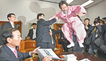 강기갑 대표 탁자 올라가 항의5일 오전 민주노동당 강기갑 대표가 박계동 국회사무총장실의 원탁에 뛰어올라가 거칠게 항의하자 직원들이 말리고 있다. 강 대표는 이날 국회 경위들이 본회의장 제1회의실 앞에 설치된 민노당의 현수막을 철거한 것에 항의하기 위해 박 총장실을 찾아갔다. 홍진환 기자