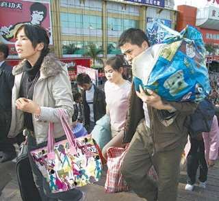 2일 춘제가 끝나면서 고향에 다녀온 중국 농민공들이 짐을 양손 가득 들고 광둥 성 둥관 시 기차역을 쉴새없이 빠져나오고 있다. 공장밀집지역인 광둥 성에서는 인력수요가 큰 폭으로 줄면서 농민공 실업이 심각한 사회문제로 떠오르고 있다. 둥관=로이터 연합뉴스