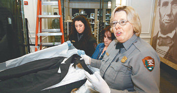 링컨 前 대통령이 피격 당시 입었던 피묻은 코트 에이브러햄 링컨 전 대통령이 암살된 장소인 워싱턴 포드극장이 링컨 탄생 200주년 하루 전날인 11일 다시 문을 열었다. 총 2500만 달러를 들여 보수공사를 마친 포드극장은 재개관 기념으로 이날부터 링컨의 일생을 다룬 연극을 올린다. 극장 직원이 링컨 전 대통령이 저격당한 당시 입고 있던 피 묻은 코트에 대해 설명하고 있다. 이 코트는 로비에 전시됐다. 워싱턴=로이터 연합뉴스